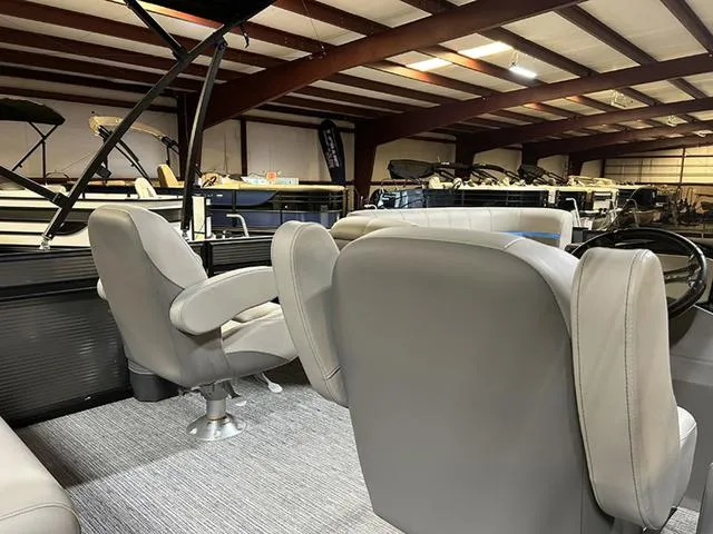 Slide: The Image of 2023 Qwest Pontoons 822 E-Class interior with plush seating in a showroom. - 12