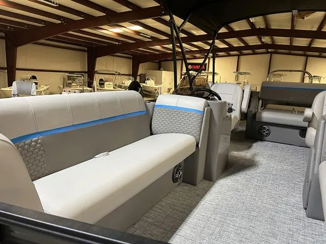 Slide: The Image of 2023 Qwest Pontoons 822 E-Class interior with spacious seating and modern design in a showroom. - 5
