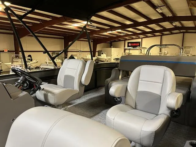Slide: The Image of 2023 Qwest Pontoons 822 E-Class interior with plush seating in a showroom setting. - 6