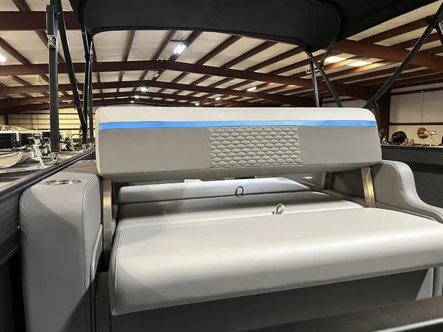 Slide: The Image of 2023 Qwest Pontoons 822 E-Class Splash Pad interior with cushioned seating in a showroom. - 9