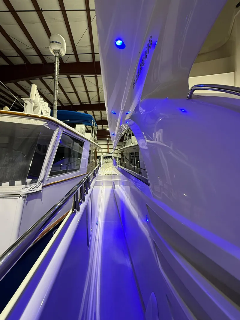 Slide: The Image of 2005 Marquis 65 yacht in a marina, illuminated by blue lights. - 12