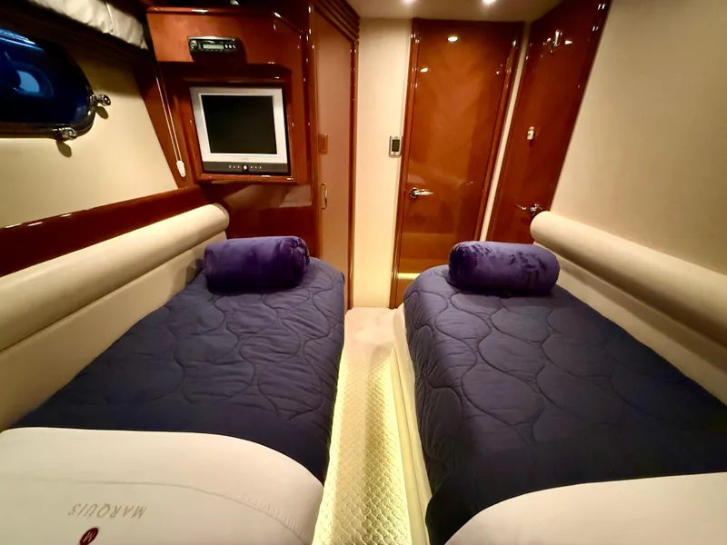 Slide: The Image of Luxurious twin cabin in 2005 Marquis 65 yacht with plush bedding and TV. - 40