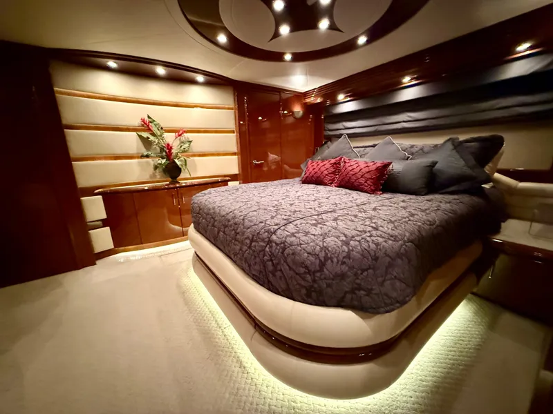 Slide: The Image of Luxurious bedroom interior of a 2005 Marquis 65 yacht, featuring elegant lighting and plush bedding. - 49