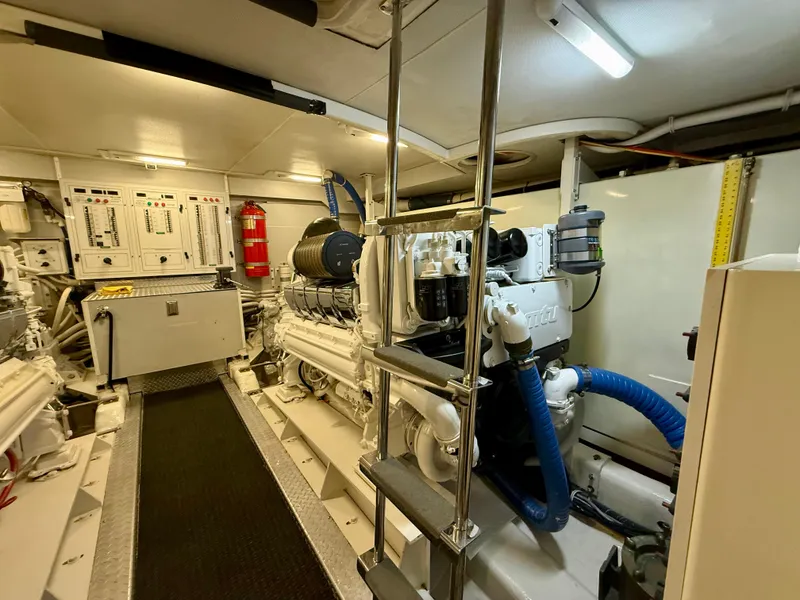 Slide: The Image of Engine room of a 2005 Marquis 65 yacht, featuring machinery and control panels. - 55