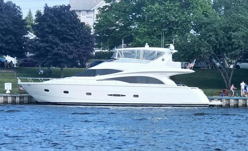Slide: The Image of 2005 Marquis 65 yacht docked by a scenic waterfront. - 6