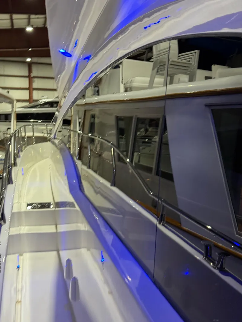 Slide: The Image of 2005 Marquis 65 yacht with sleek design and blue accent lighting in a showroom. - 9