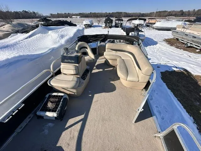 Slide: The Image of 2012 Sun Tracker Bass Buggy 18 DLX pontoon boat with beige seating, parked in snowy marina. - 4