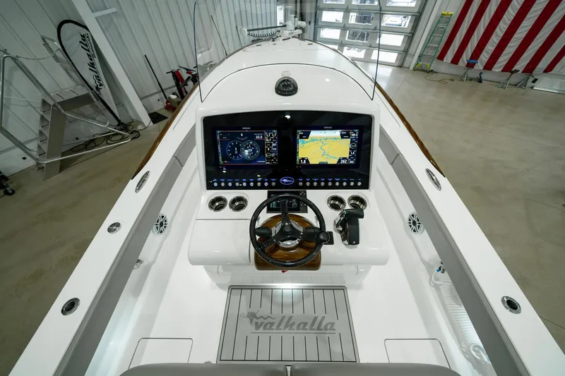 Slide: The Image of 2024 Valhalla V-28 boat helm with dual displays and steering wheel in a showroom. - 19