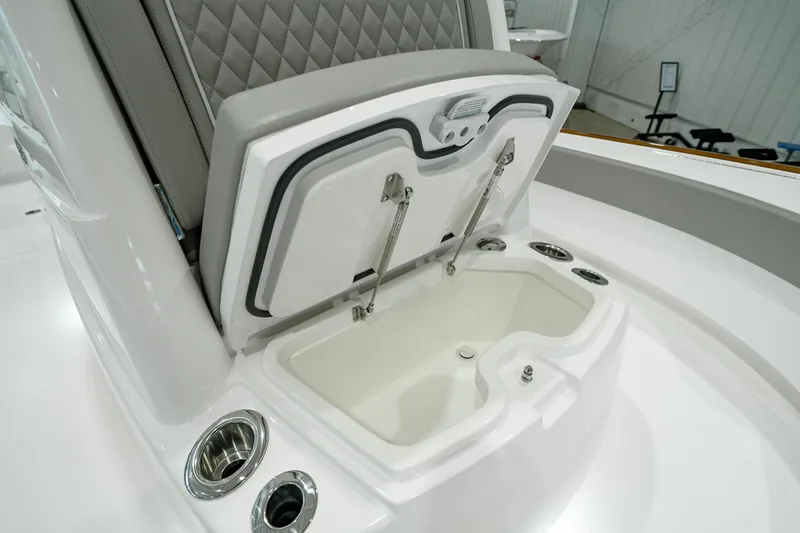 Slide: The Image of 2024 Valhalla V-28 boat storage compartment with cushioned seating and cup holders. - 26