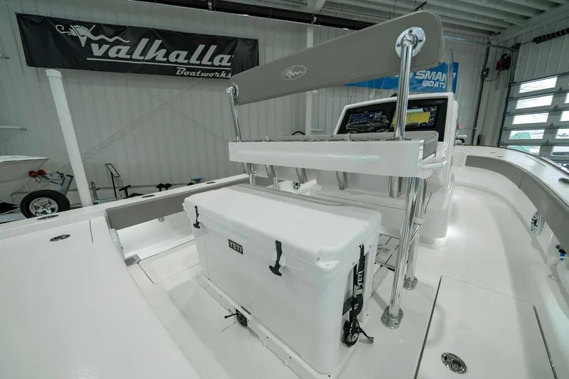 Slide: The Image of 2024 Valhalla Boatworks V-28 interior with console and cooler in a showroom. - 29