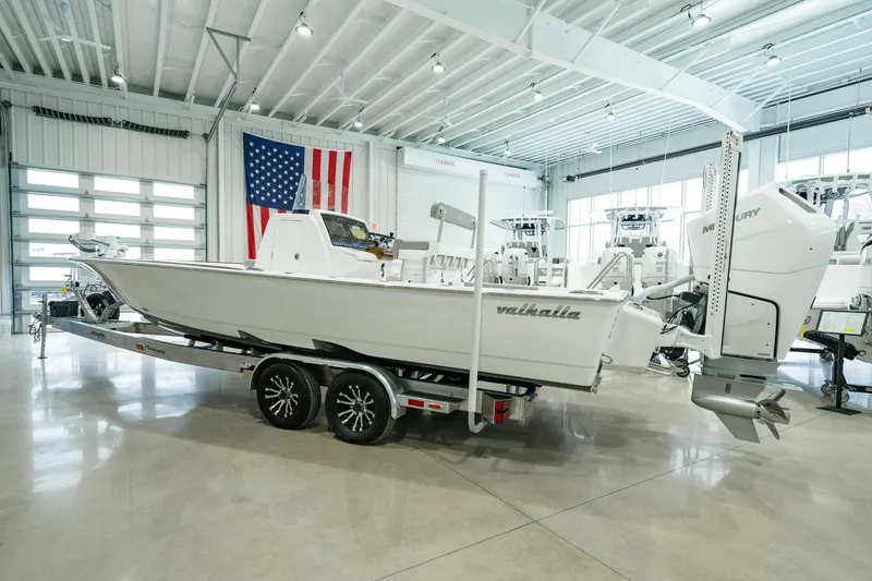 Slide: The Image of 2024 Valhalla Boatworks V-28 on trailer in showroom with American flag backdrop. - 3