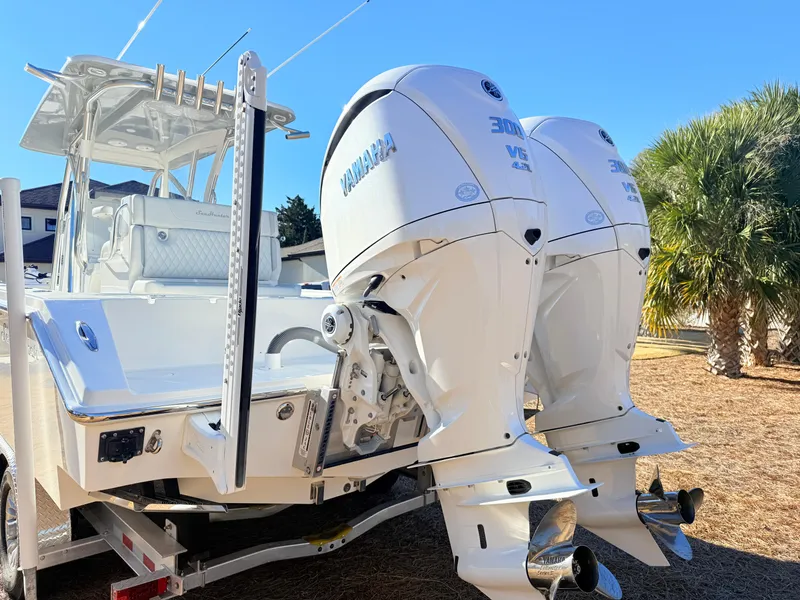 Slide: The Image of 2024 SeaHunter 28 Floridian boat with dual Yamaha outboard engines, parked outdoors. - 12