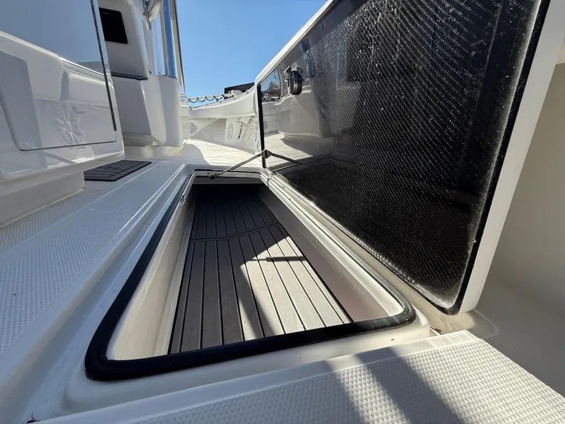 Slide: The Image of 2024 SeaHunter 28 Floridian boat storage compartment with open hatch, showcasing sleek design. - 16