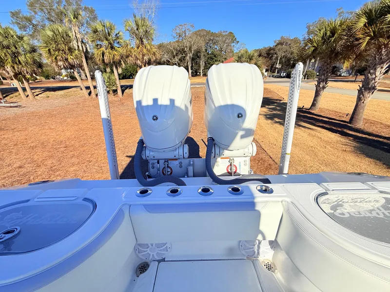 Slide: The Image of 2024 SeaHunter 28 Floridian boat with dual engines, parked outdoors. - 28