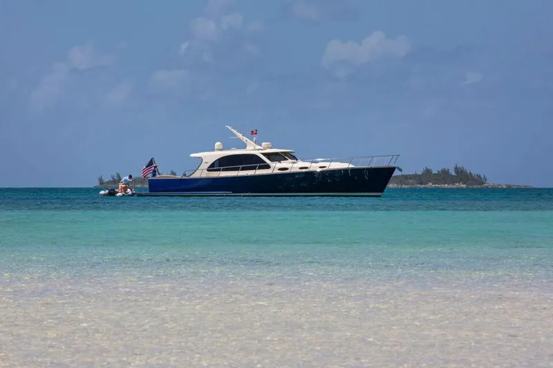 Slide: The Image of 2026 Palm Beach Motor Yachts PB55 cruising on turquoise waters under a clear sky. - 16