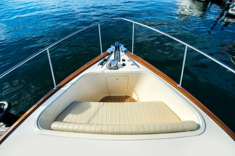 Slide: The Image of 2026 Palm Beach Motor Yachts PB55 bow with cushioned seating, surrounded by calm water. - 5