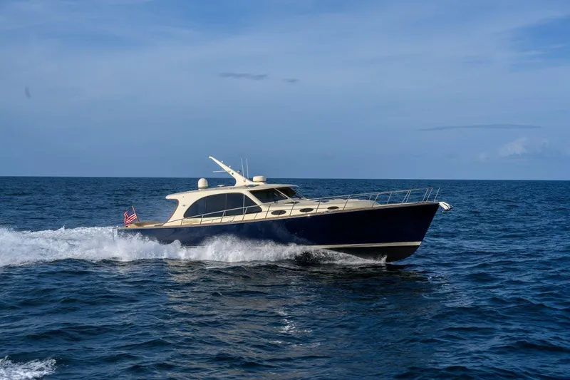 Slide: The Image of 2026 Palm Beach Motor Yachts PB55 cruising on open water under a clear blue sky. - 17