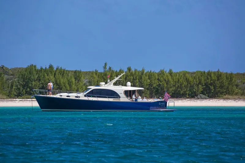 Slide: The Image of 2026 Palm Beach Motor Yachts PB55 cruising near a tropical shoreline. - 23