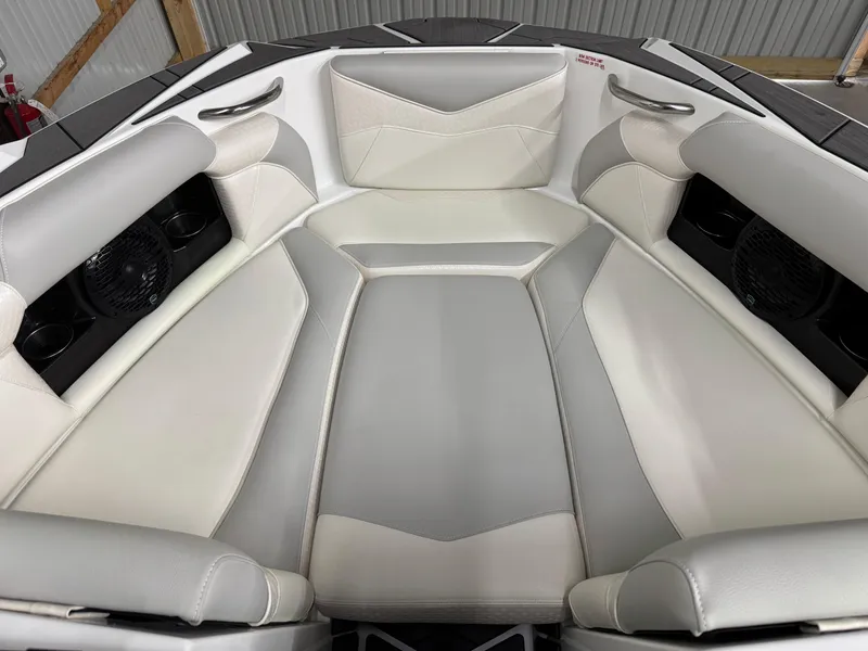 Slide: The Image of 2025 Supreme S220 boat interior with white and gray seating, featuring built-in speakers. - 13