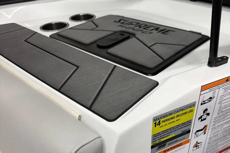 Slide: The Image of 2025 Supreme S220 boat interior with cup holders and capacity warning label. - 16