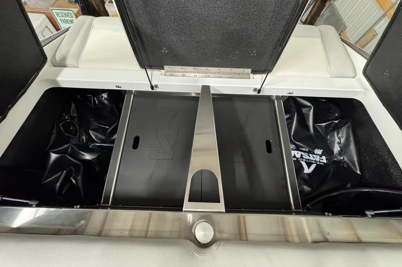 Slide: The Image of 2025 Supreme S220 boat storage compartment with open lids and black interior. - 19