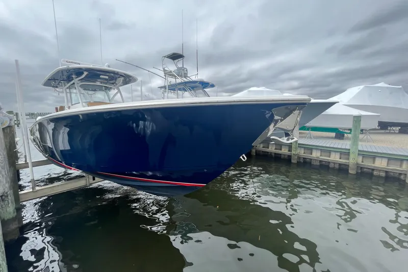 The Image of 2023 Valhalla Boatworks V-37 in marina, sleek design, blue hull, overcast sky. - 0