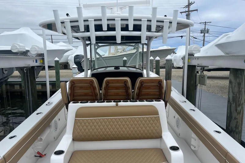 Slide: The Image of 2023 Valhalla Boatworks V-37 with tan seating, docked at a marina. - 10