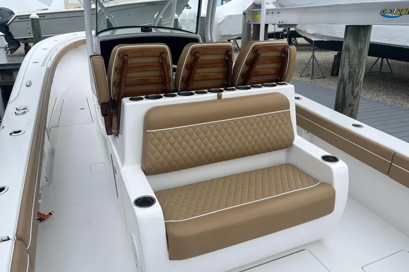 Slide: The Image of 2023 Valhalla Boatworks V-37 interior with tan quilted seating and cup holders. - 11