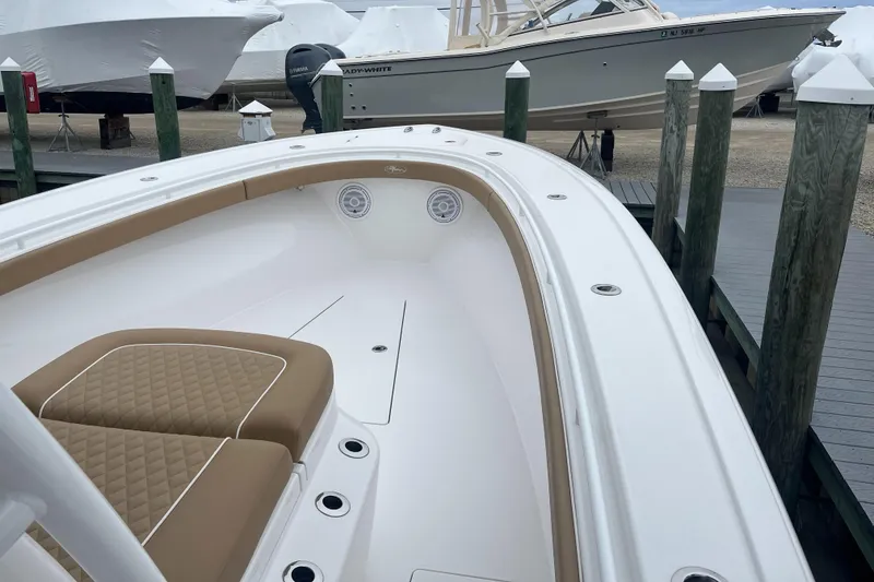 Slide: The Image of 2023 Valhalla Boatworks V-37 with tan seating, docked at a marina. - 6