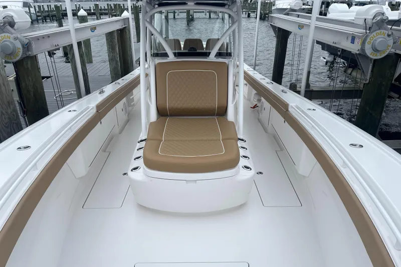 Slide: The Image of 2023 Valhalla Boatworks V-37 with tan seating, docked at a marina. - 7