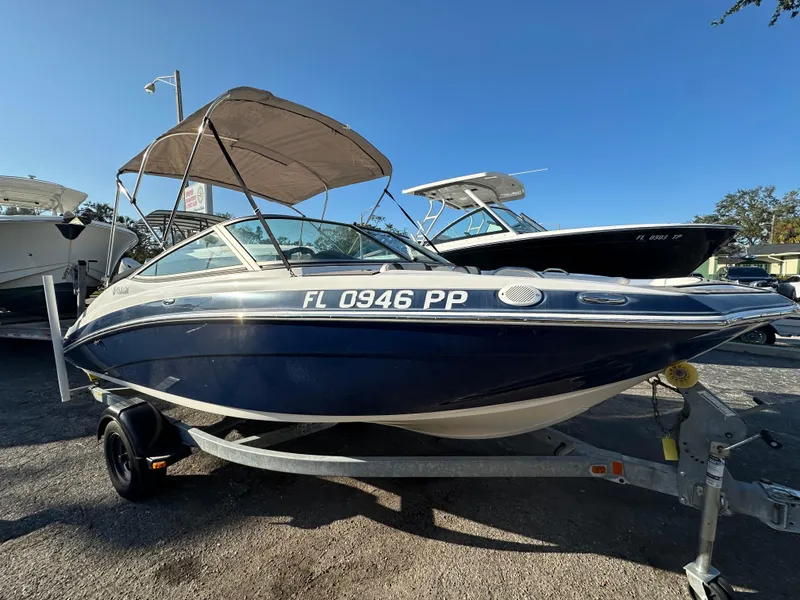 The Image of 2013 Yamaha Boats SX192 on trailer, blue and white, with canopy. - 1
