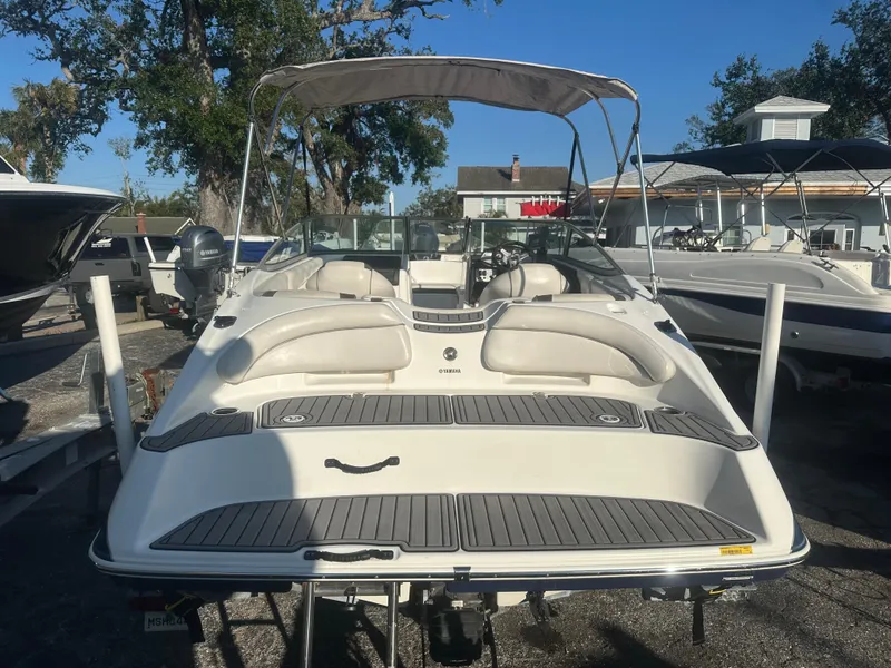 Slide: The Image of 2013 Yamaha Boats SX192, white, parked outdoors, with canopy and seating area visible. - 10