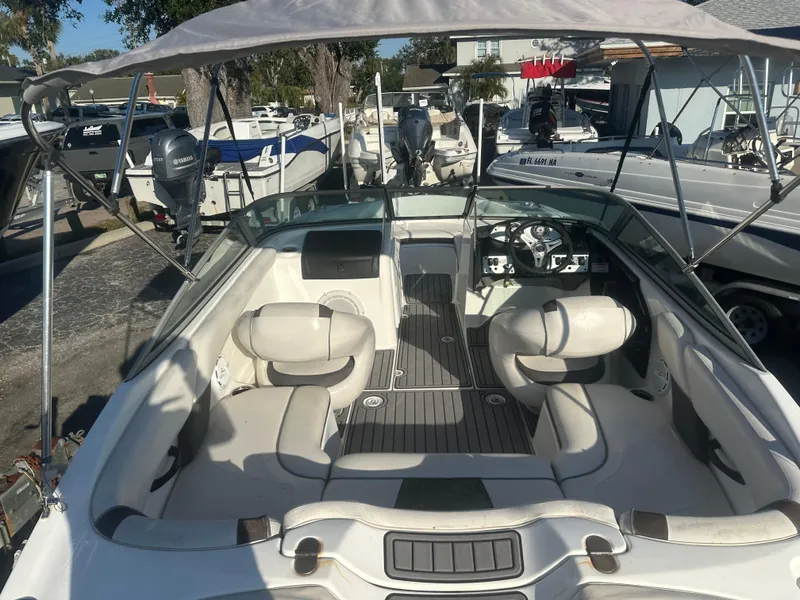 Slide: The Image of 2013 Yamaha Boats SX192 interior with seating and steering wheel, docked among other boats. - 11