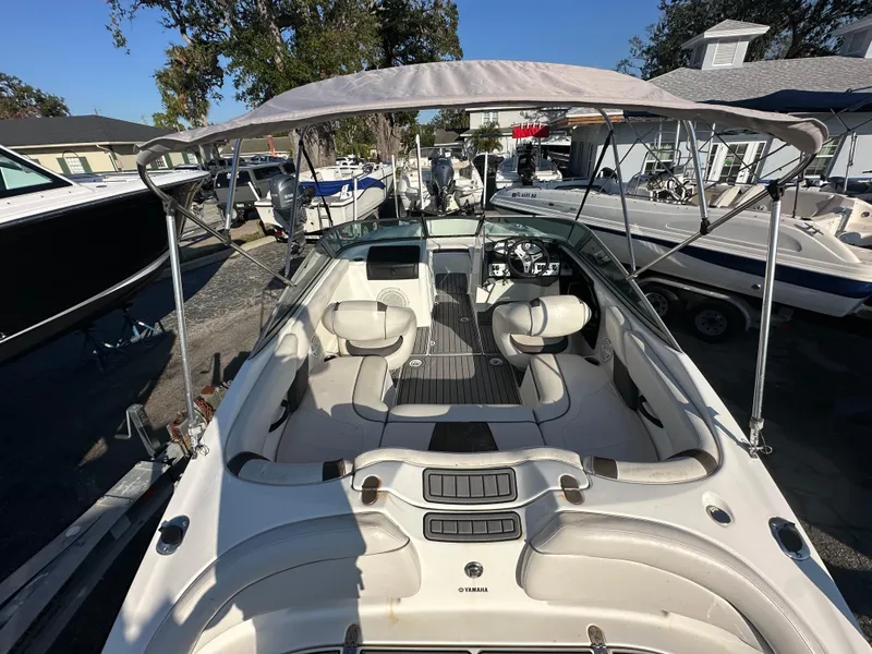 Slide: The Image of 2013 Yamaha Boats SX192 with canopy, spacious seating, and modern dashboard in a marina setting. - 12