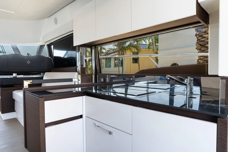 Slide: The Image of Modern kitchen interior on 2023 Prestige 460 Fly yacht, featuring sleek cabinetry and glossy surfaces. - 16