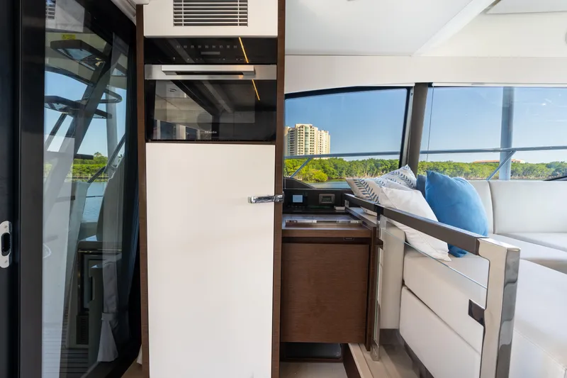 Slide: The Image of Interior of 2023 Prestige 460 Fly yacht with modern design and scenic window view. - 17