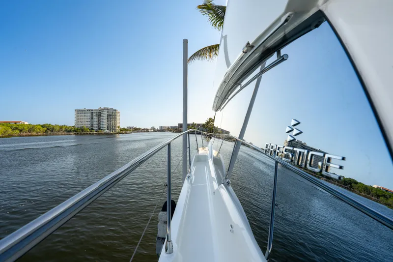 Slide: The Image of 2023 Prestige 460 Fly yacht cruising on a scenic waterway with city skyline. - 3