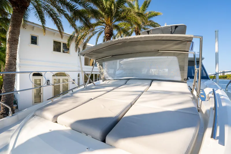 Slide: The Image of 2023 Prestige 460 Fly yacht with sunbed, palm trees, and house in background. - 4