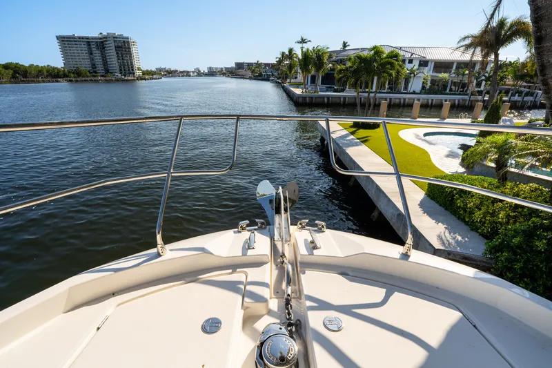 Slide: The Image of Prestige 460 Fly 2023 yacht cruising near waterfront homes and palm trees. - 5