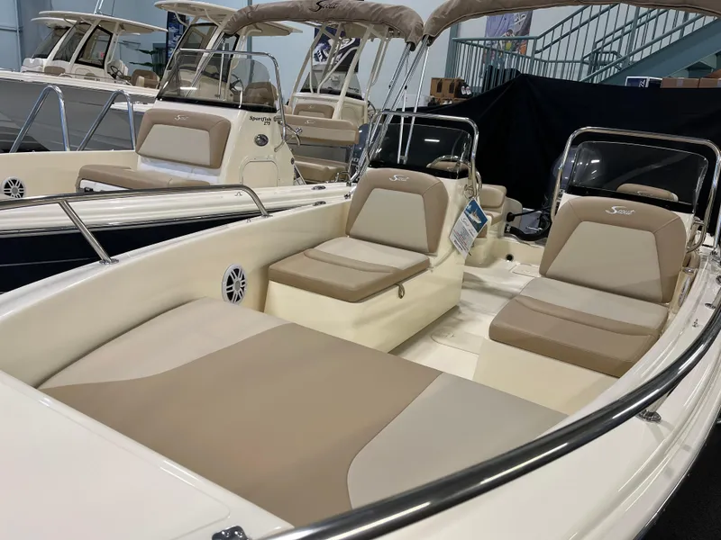 Slide: The Image of 2025 Scout 175 Sport Dorado boat with beige seating in showroom. - 2