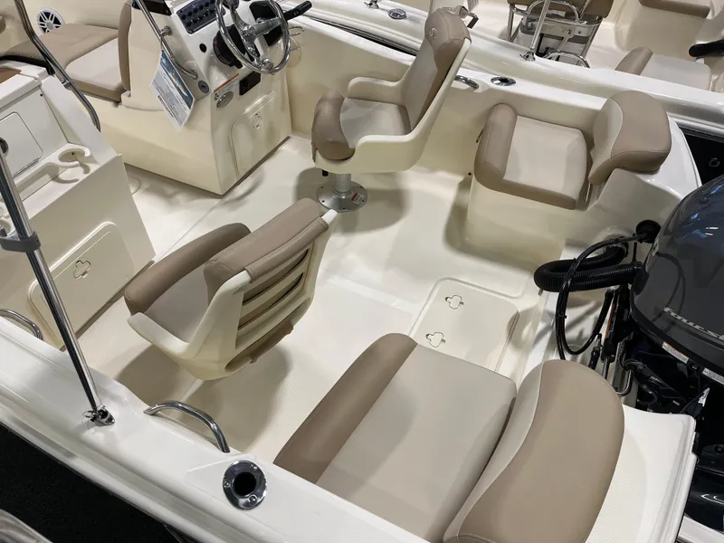 Slide: The Image of 2025 Scout 175 Sport Dorado boat interior with beige seating and steering console. - 3
