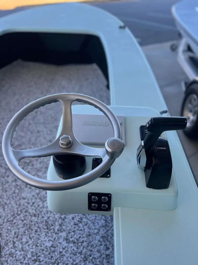 Slide: The Image of 2024 Chittum Skiffs Challenger 18 steering wheel and controls, close-up view. - 14