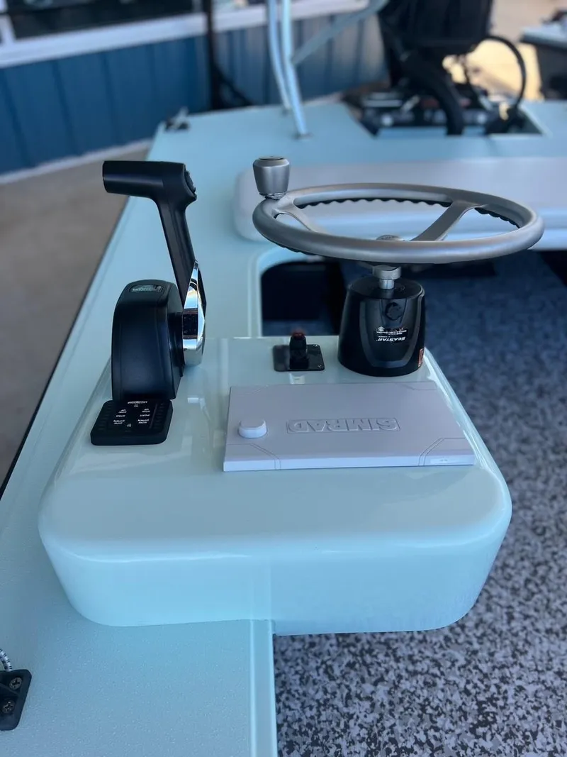 Slide: The Image of 2024 Chittum Skiffs Challenger 18 steering console with throttle and controls. - 15