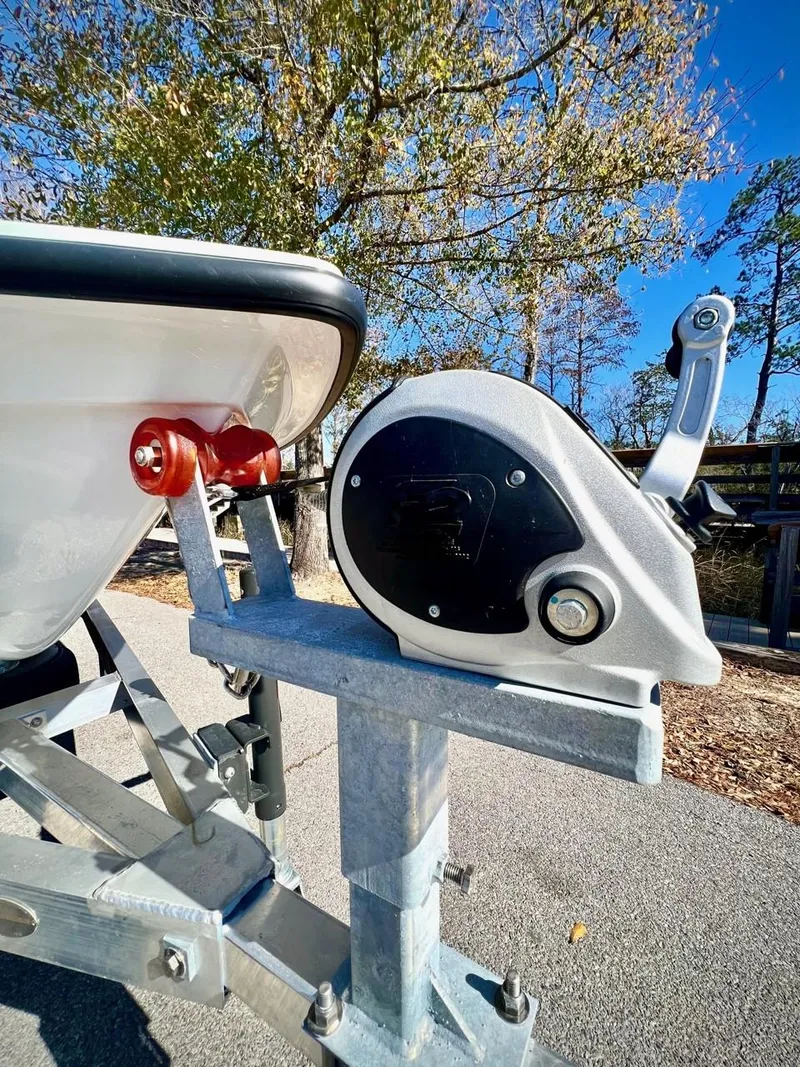 Slide: The Image of 2024 Chittum Skiffs Challenger 18 trailer winch, close-up view with trees in background. - 8