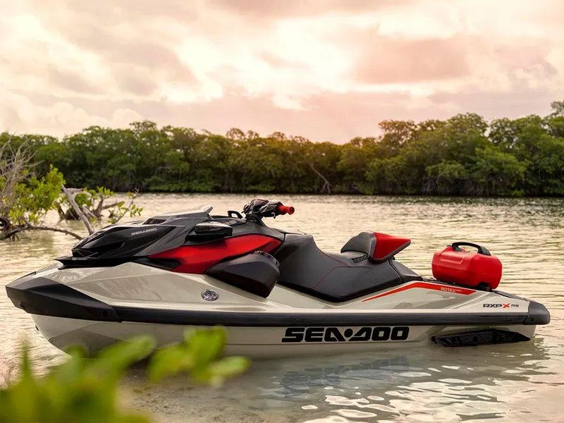 Slide: The Image of 2025 Sea-Doo RXP-X 325 Tech Package jet ski on calm water at sunset. - 14