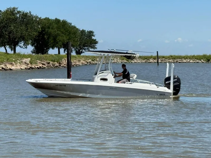 Slide: The Image of 2014 Boston Whaler 240 Dauntless boat cruising on a calm river. - 14