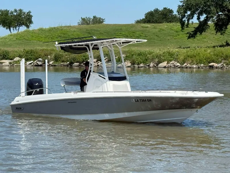 Slide: The Image of 2014 Boston Whaler 240 Dauntless boat cruising on a calm river. - 18