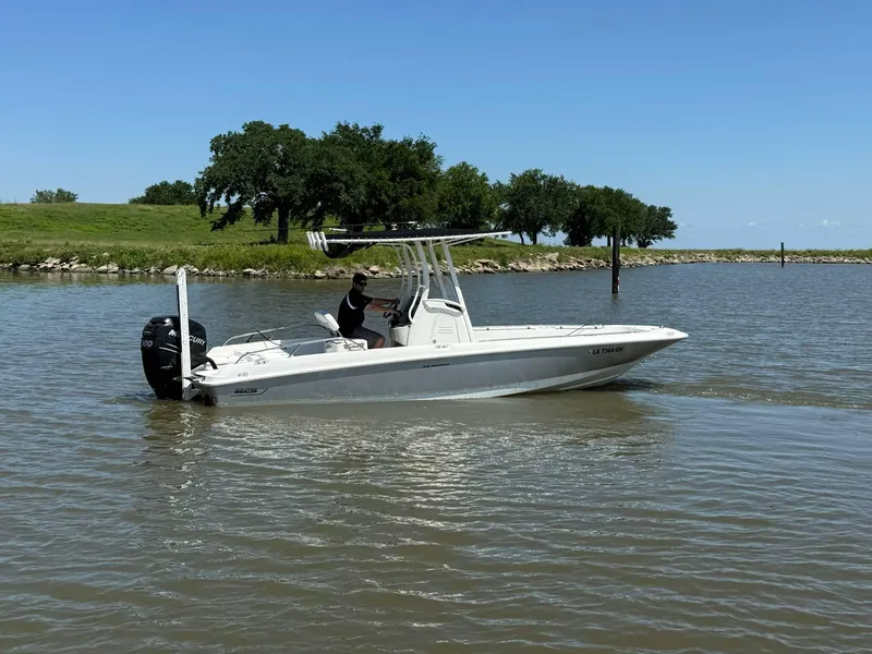 Slide: The Image of 2014 Boston Whaler 240 Dauntless boat cruising on a calm lake under a clear blue sky. - 21