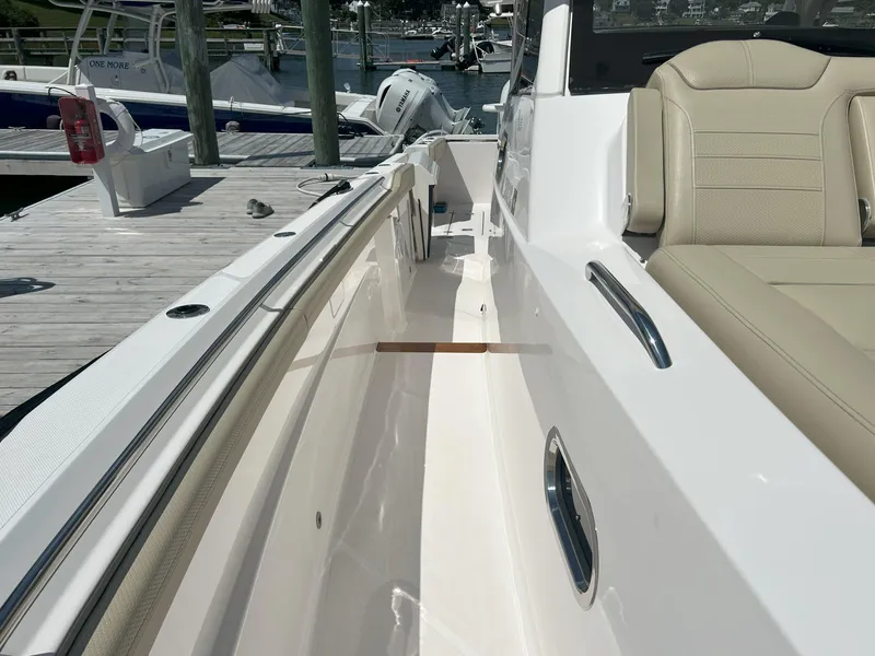 Slide: The Image of 2019 Pursuit S 408 Sport boat interior with beige seating and sleek white deck. - 12