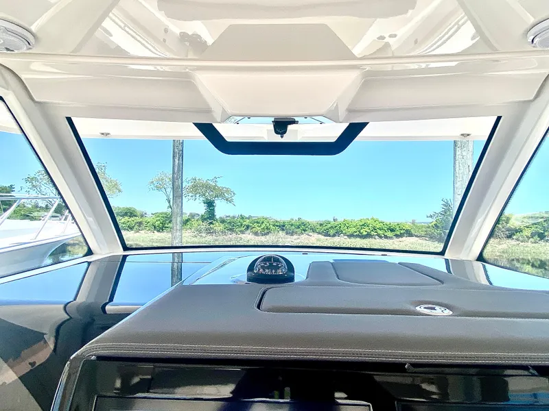 Slide: The Image of 2019 Pursuit S 408 Sport boat interior with clear windshield and dashboard view. - 14
